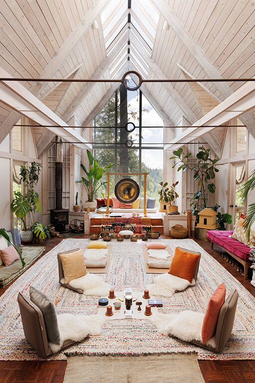 The sound sanctuary at Spirit Camp — white-painted wood, peaked skylights, sheepskin floor cushions arranged in a square.